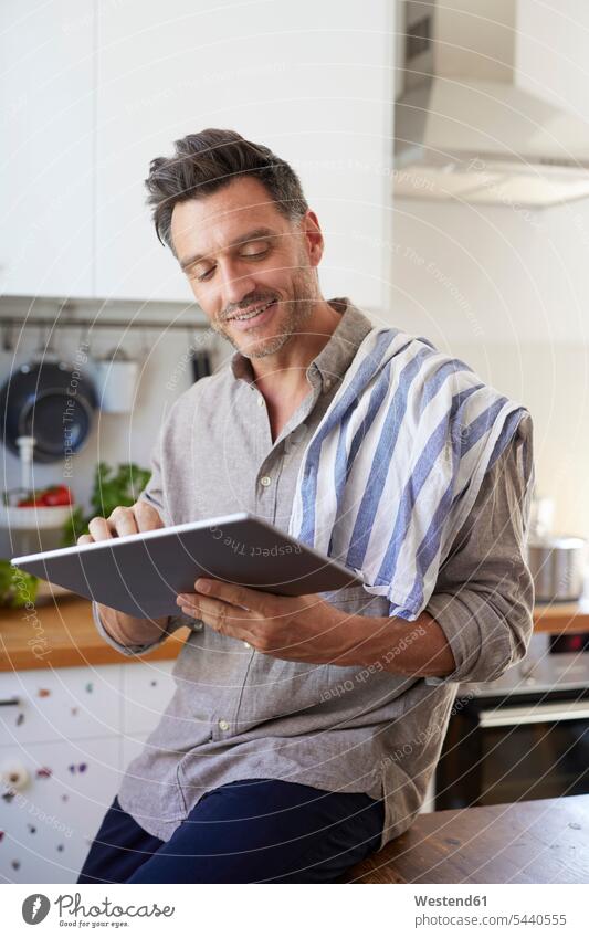 Porträt eines lächelnden Mannes mit Tablette in der Küche benutzen benützen Portrait Porträts Portraits Tablet Computer Tablet-PC Tablet PC iPad Tablet-Computer
