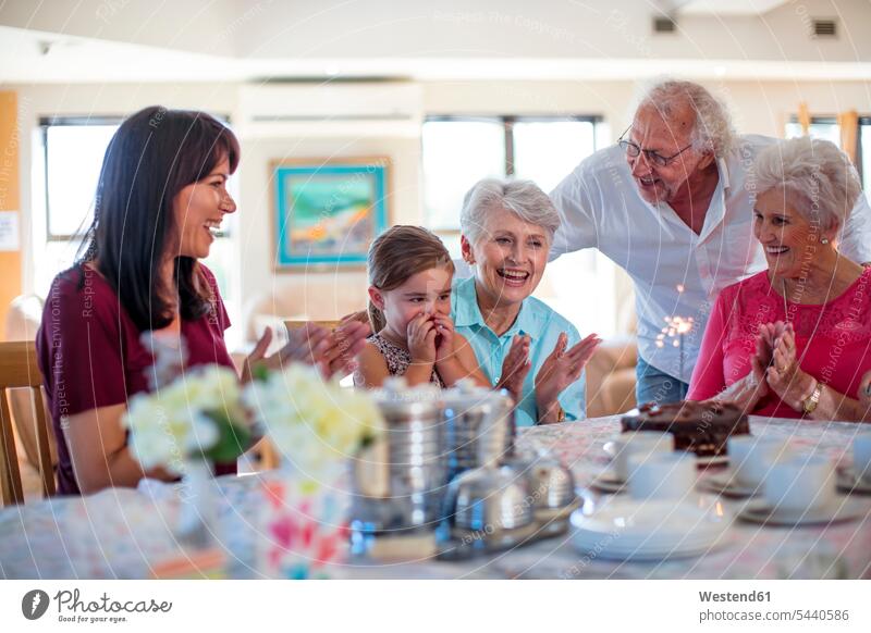 Großeltern, die mit ihrer Enkelin Geburtstag feiern Geburtstagsfeiern Geburtstage lachen Enkeltochter Enkelinnen Enkeltöchter Unbeschwert Sorglos glücklich