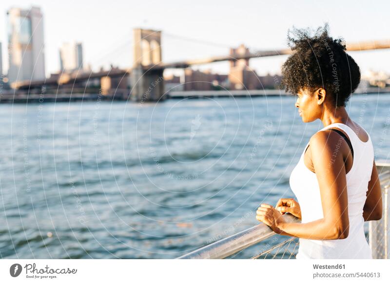 USA, New York City, Brooklyn, Frau am Wasser stehend Fluss Fluesse Fluß Flüsse Brücke Bruecken Brücken weiblich Frauen steht Gewässer Erwachsener erwachsen