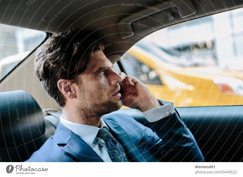 Geschäftsmann sitzt im Taxi und benutzt ein Smartphone attraktiv schoen gut aussehend schön Attraktivität gutaussehend hübsch telefonieren anrufen Anruf