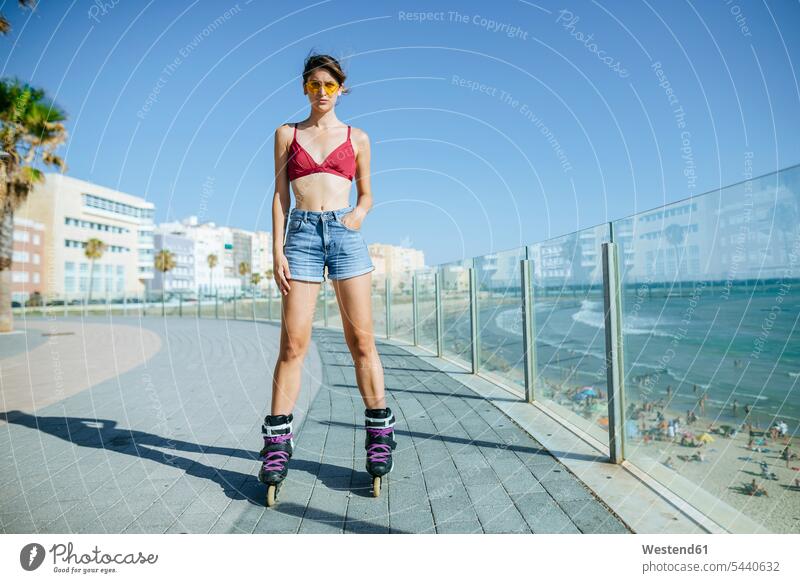 Junge Frau auf Inline-Skates auf der Strandpromenade an der Küste Inlineskates Inline skates inline skate Inliner weiblich Frauen Rollerblades Inlineskaten