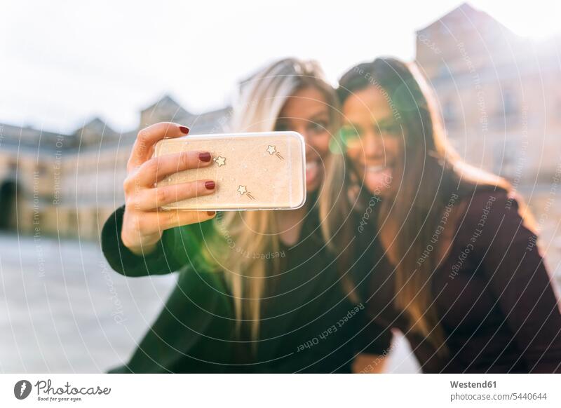 Zwei verspielte junge Frauen machen ein Selfie Handy Mobiltelefon Handies Handys Mobiltelefone Freundinnen Selfies weiblich Freunde Freundschaft Kameradschaft