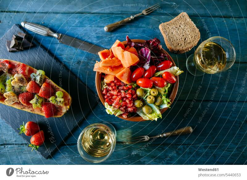 Salat mit Tomate, Granatapfel, Papaya und Oliven, mit Papaya und einem Glas Wein Weißweinglas Weissweinglas Weißweingläser Weissweinglaeser Erdbeere Erdbeeren