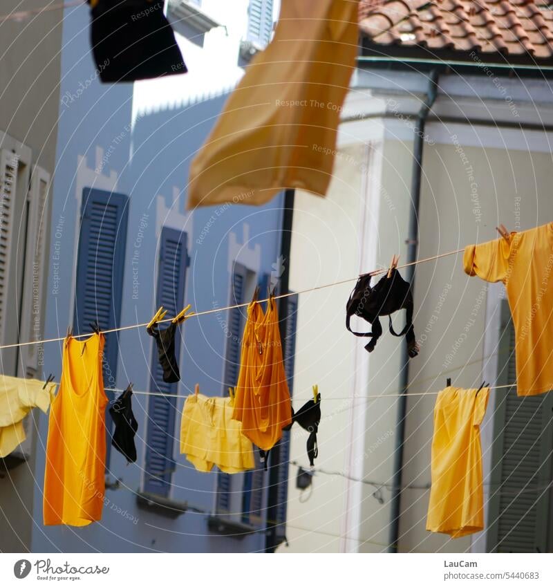 Weichspüler | schwarz-gelbe Wäsche weht duftend in einer Gasse gewaschen trocknen lüften BH Unterhemd Tshirt Büstenhalter Umtetwäsche hängen Wäscheleine sauber