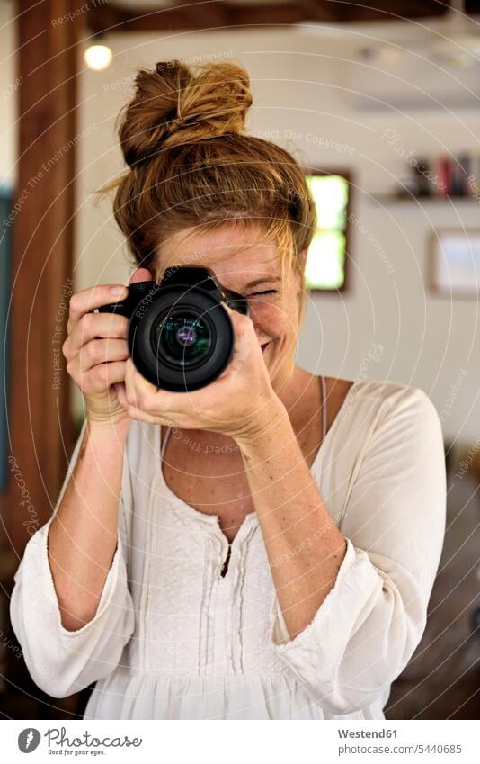 Porträt einer lachenden jungen Frau, die mit der Kamera fotografiert Kameras fotografieren Fotoapparat Fotokamera positiv Emotion Gefühl Empfindung Emotionen