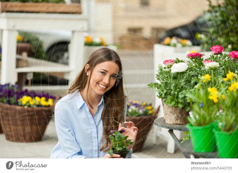 Junge Frau kauft Topfblumen weiblich Frauen Topfpflanze Topfpflanzen Blume Blumen Blüte gärtnern Gartenarbeit Gartenbau kaufen Kauf fröhlich Fröhlichkeit