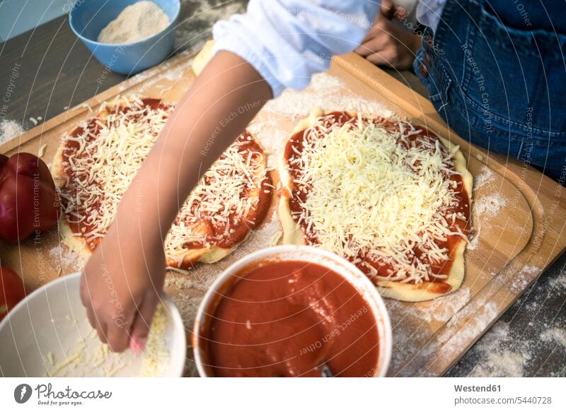 Mädchen in der Küche lernt Pizza backen, Käse bestreuen Küchen Pizzen lernen Kaese weiblich Essen Food Food and Drink Lebensmittel Essen und Trinken