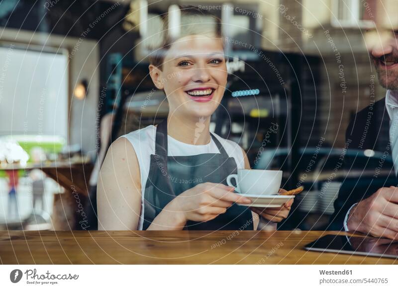Lächelnde Kellnerin serviert dem Kunden im Café Kaffee lächeln Cafe Kaffeehaus Bistro Cafes Cafés Kaffeehäuser Restaurantfachfrau Kellnerinnen Geschäftsmann