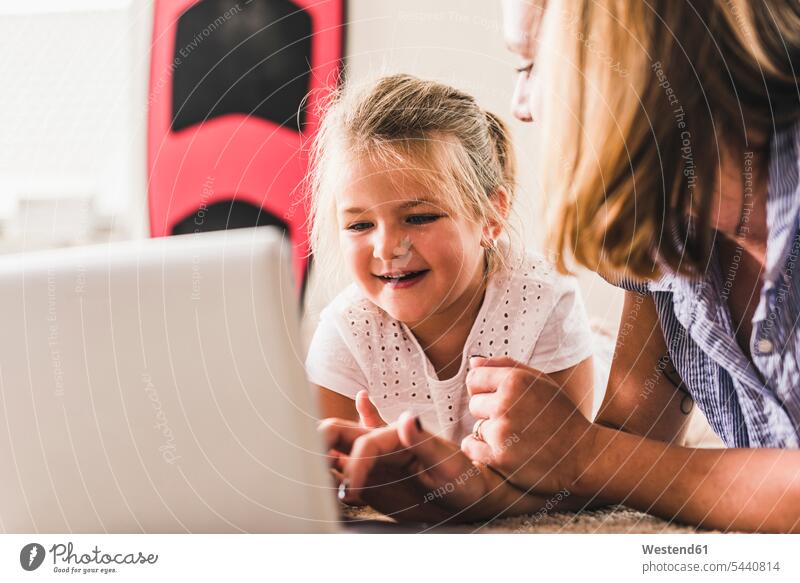 Mutter und Tochter amüsieren sich am Laptop Töchter Mami Mutti Mütter Mama lachen Notebook Laptops Notebooks Zuhause zu Hause daheim Kind Kinder Familie
