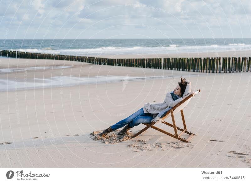 Frau sitzt auf Liegestuhl am Strand sitzen sitzend Beach Straende Strände Beaches weiblich Frauen Erwachsener erwachsen Mensch Menschen Leute People Personen