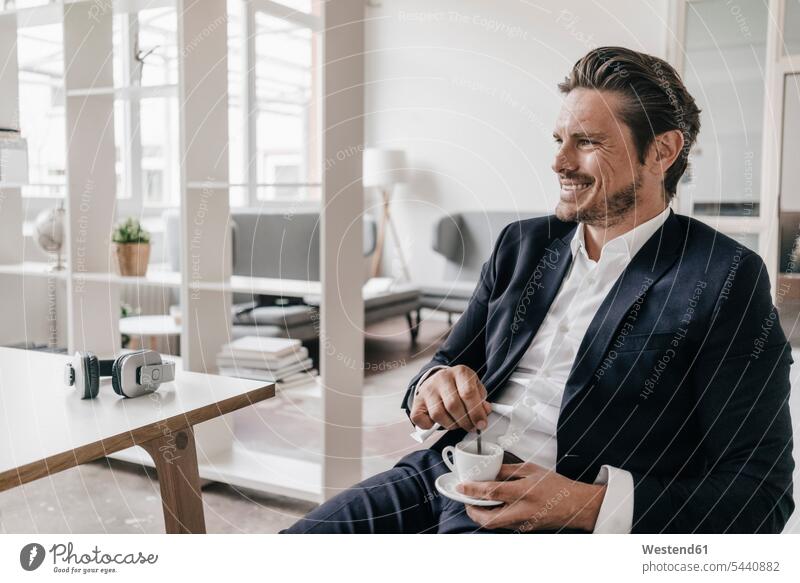 Lächelnder Geschäftsmann bei einer Kaffeepause Mann Männer männlich lächeln Businessmann Businessmänner Geschäftsmänner Pause Erwachsener erwachsen Mensch