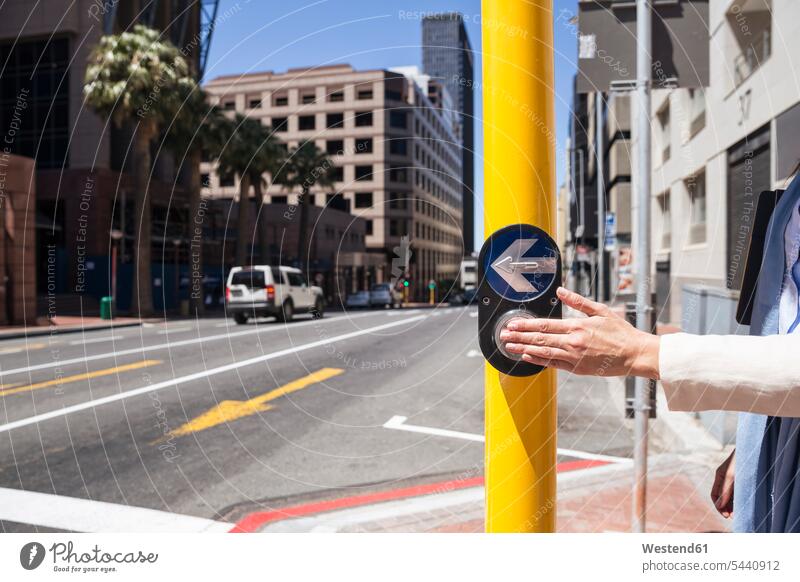 Reife Frau, die in der Stadt spazieren geht und die Straße überquert weiblich Frauen drücken Hand Hände Städtische Straße Strassen Straßen Knopf Knoepfe Knöpfe