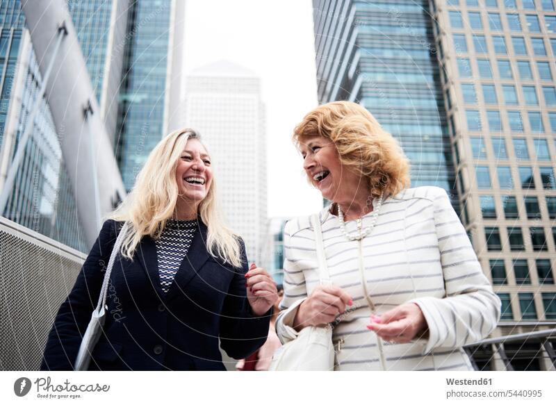 UK, London, zwei glückliche ältere Geschäftsfrauen in der Stadt Frau weiblich Frauen Kollegin Kolleginnen lachen Businesswomen Businessfrauen Businesswoman