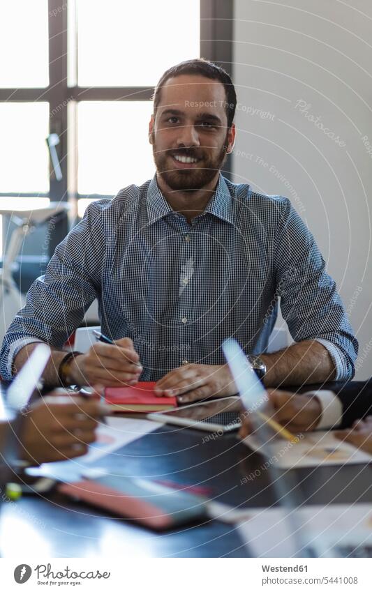 Porträt eines lächelnden Geschäftsmannes während einer Sitzung im Amt Büro Office Büros Arbeitsplatz Arbeitsstätte Arbeitstelle Meeting Business Meeting
