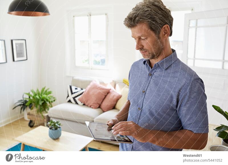 Reifer Mann zu Hause mit digitalem Tablett Internet Tablet Computer Tablet-PC Tablet PC iPad Tablet-Computer Smart Home smarthome Zuhause daheim Männer männlich