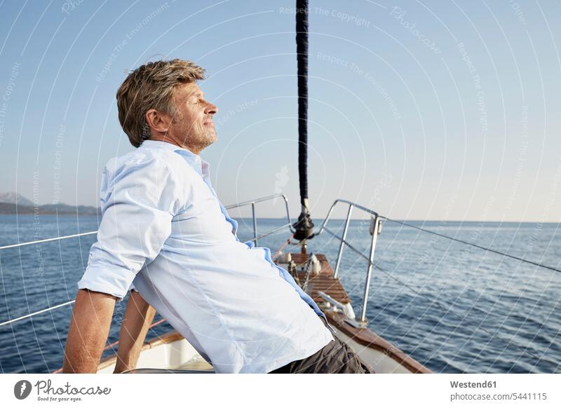 Reifer Mann entspannt sich auf seinem Segelboot Männer männlich Segeln segelnd segelt Erwachsener erwachsen Mensch Menschen Leute People Personen Bootsport