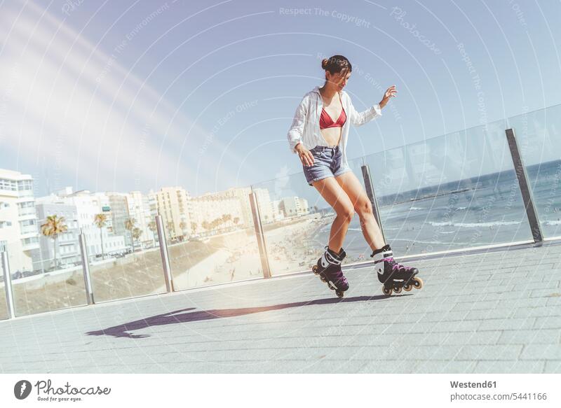 Junge Frau beim Inlineskaten auf der Strandpromenade an der Küste Inlineskates Inline skates inline skate Inliner fahren weiblich Frauen Rollerblades