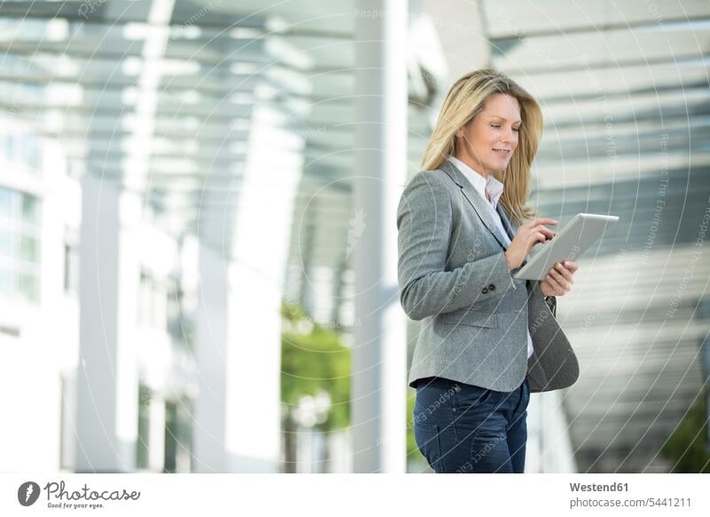 Geschäftsfrau benutzt Tablette im Freien lächeln Geschäftsfrauen Businesswomen Businessfrauen Businesswoman Tablet Computer Tablet-PC Tablet PC iPad