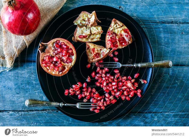 Granatapfelhälfte, Granatapfelkern und zwei alte Gabeln auf Schwarzblech Niemand Zubereitung zubereiten Frische frisch Gesunde Ernährung Ernaehrung