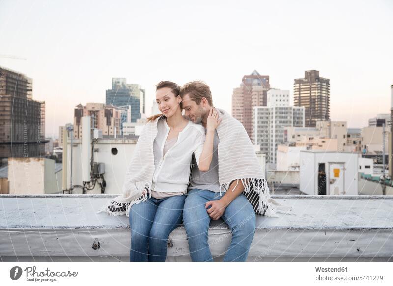 Romantisches Paar sitzt auf der Dachterrasse und genießt die Aussicht Pärchen Paare Partnerschaft flirten Flirt sitzen sitzend frisch verliebt sich verlieben