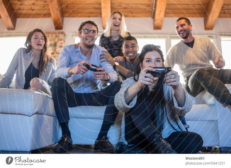 Freunde spielen Computerspiel zu Hause Computerspiele Spielkonsole Spielkonsolen Konsole Freundschaft Kameradschaft sitzen sitzend sitzt Sofa Couches Liege