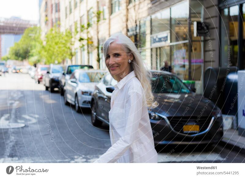 USA, Brooklyn, Porträt einer lächelnden reifen Frau beim Überqueren der Straße weiblich Frauen Erwachsener erwachsen Mensch Menschen Leute People Personen