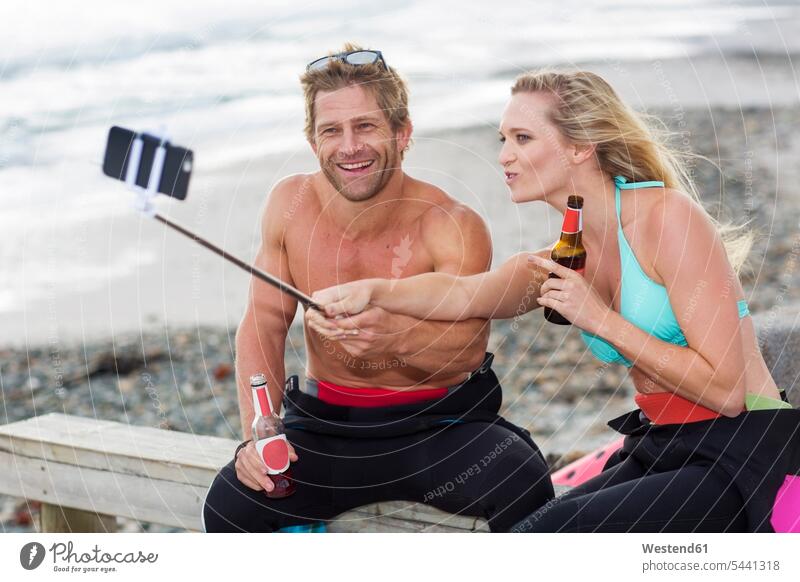Ein Paar hat Spaß am Strand und macht ein Selfie Beach Straende Strände Beaches lachen Selfies Pärchen Paare Partnerschaft Handy Mobiltelefon Handies Handys