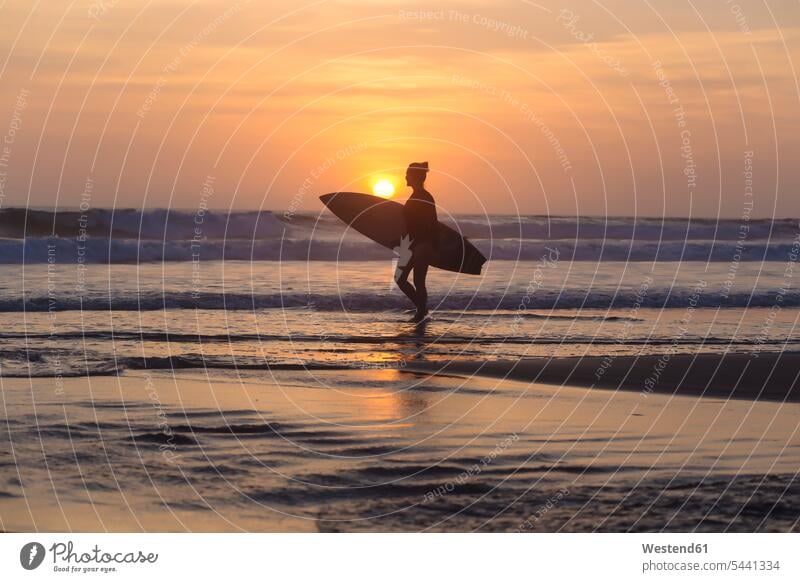 Indonesien, Bali, junge Frau mit Surfbrett Freizeit Muße gehen gehend geht Silhouette Umriß Gegenlicht Schattenbilder Silhouetten Konturen Umriss Umrisse