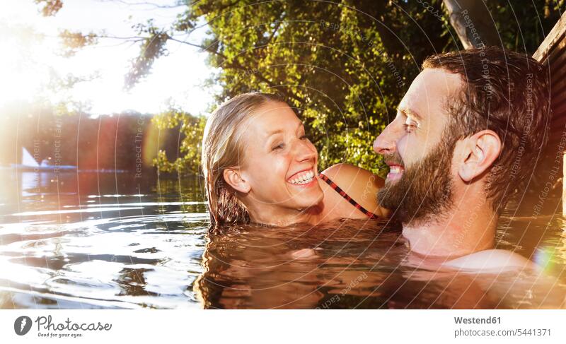 Glückliches junges Paar in einem See Seen Pärchen Paare Partnerschaft schwimmen glücklich glücklich sein glücklichsein Gewässer Wasser Mensch Menschen Leute