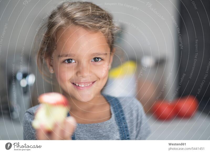 Porträt eines lächelnden Mädchens mit Apfel in der Küche Portrait Porträts Portraits Äpfel Aepfel Obst Früchte Essen Food Food and Drink Lebensmittel