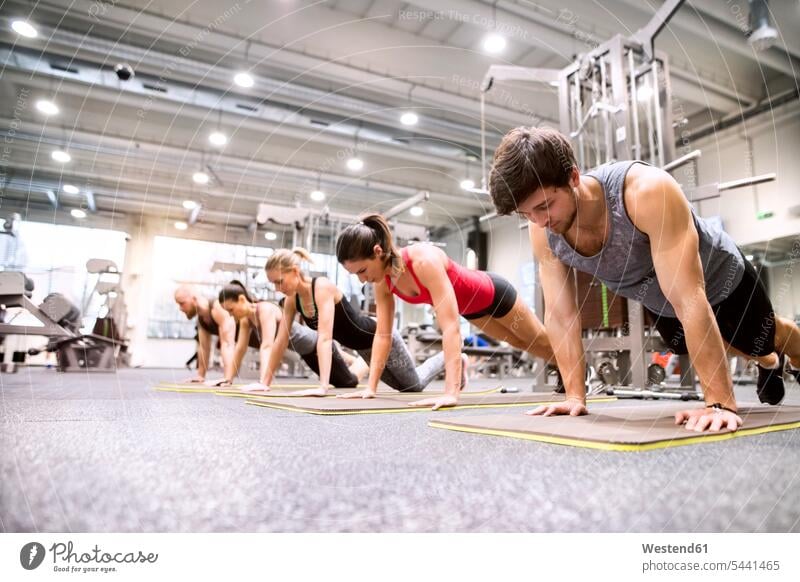 Gruppe von Sportlern, die im Fitnessstudio trainieren Liegestützen Push-Up Pushups Push-Ups Fitnessclubs Fitnessstudios Turnhalle Muskeltraining fit Gesundheit