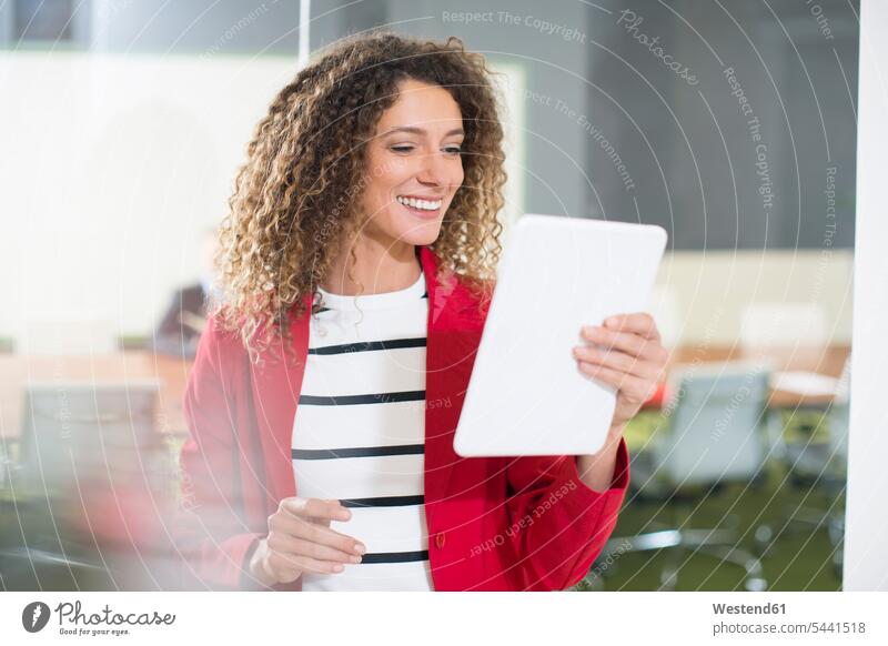 Lächelnde Geschäftsfrau mit Tablett im Büro Tablet Computer Tablet-PC Tablet PC iPad Tablet-Computer Portrait Porträts Portraits lächeln Office Büros Rechner