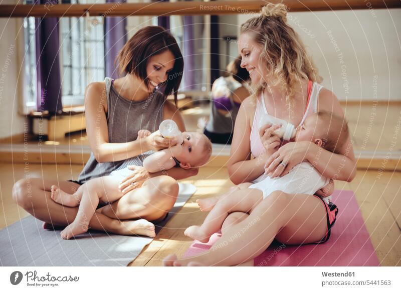 Zwei Mütter füttern ihre Babys im Übungsraum mit der Flasche Babies Säuglinge Kind Kinder Mutter Mami Mutti Mama trainieren Spaß Spass Späße spassig Spässe