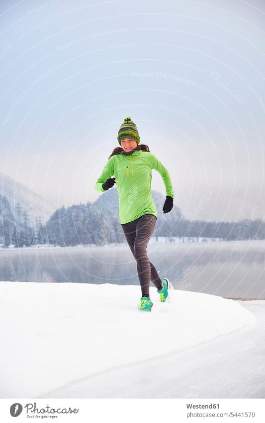 Deutschland, Bayern, Kochelsee, Frau beim Joggen im Winter trainieren laufen rennen Jogging weiblich Frauen Fitness fit Gesundheit gesund Sport Erwachsener