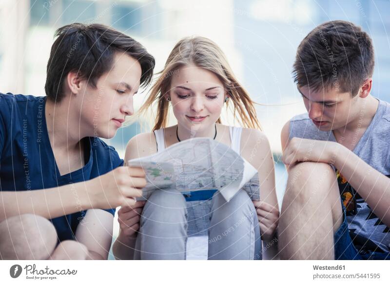 Junge Leute reisen durch Europa, schauen auf die Karte Reisende Reisender sitzen sitzend sitzt Stadtplan Stadtpläne Teenager Jugendlicher Sightseeing