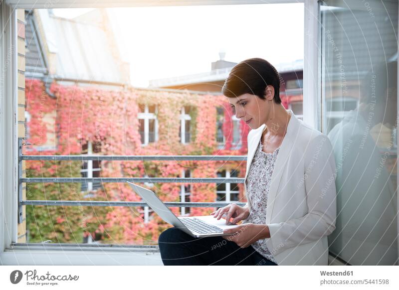 Frau mit Laptop am Fenster Geschäftsfrau Geschäftsfrauen Businesswomen Businessfrauen Businesswoman Notebook Laptops Notebooks weiblich Frauen arbeiten Arbeit
