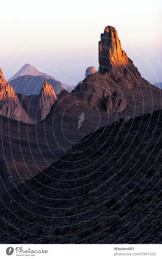 Algerien, Wilaya Tamanrasset, Hoggar-Gebirge mit Vulkangestein in der Dämmerung morgens Morgen früh Frühe Ruhe Beschaulichkeit ruhig Felsformation Felsengruppe