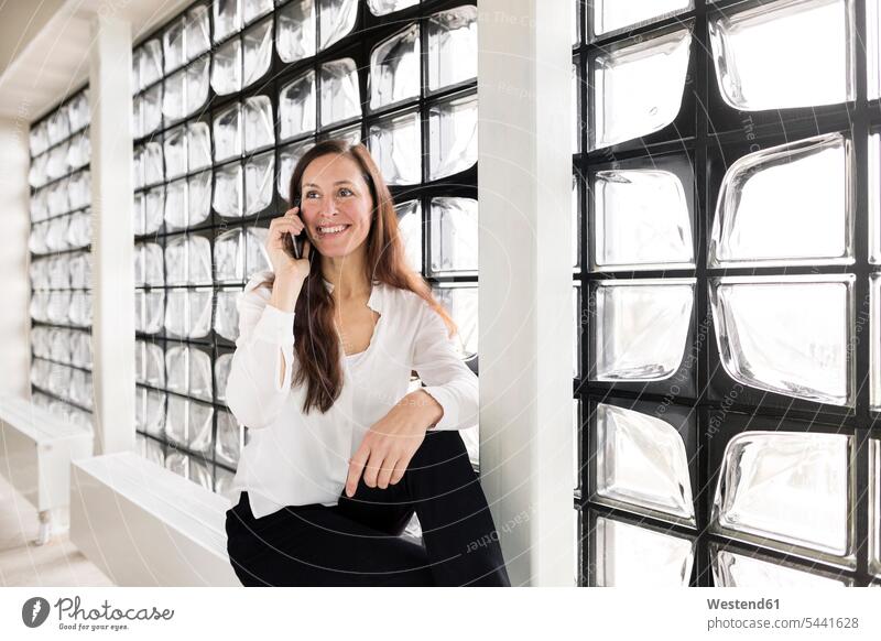 Porträt einer lächelnden Geschäftsfrau am Telefon Frau weiblich Frauen Portrait Porträts Portraits telefonieren anrufen Anruf telephonieren Erwachsener