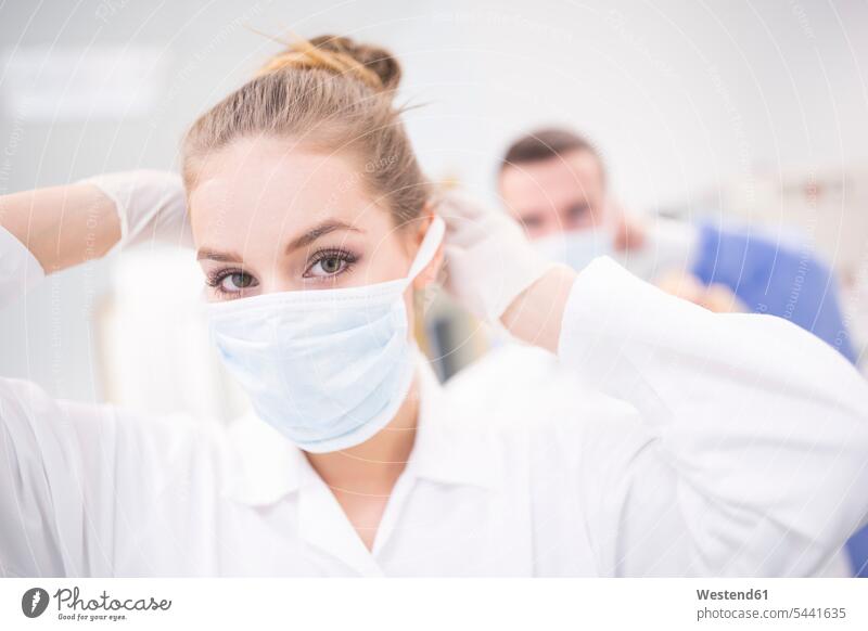 Porträt eines Laboranten beim Anlegen der Maske Mundschutz Portrait Porträts Portraits Wissenschaftlerin Wissenschaftlerinnen Labore anziehen anlegen Masken