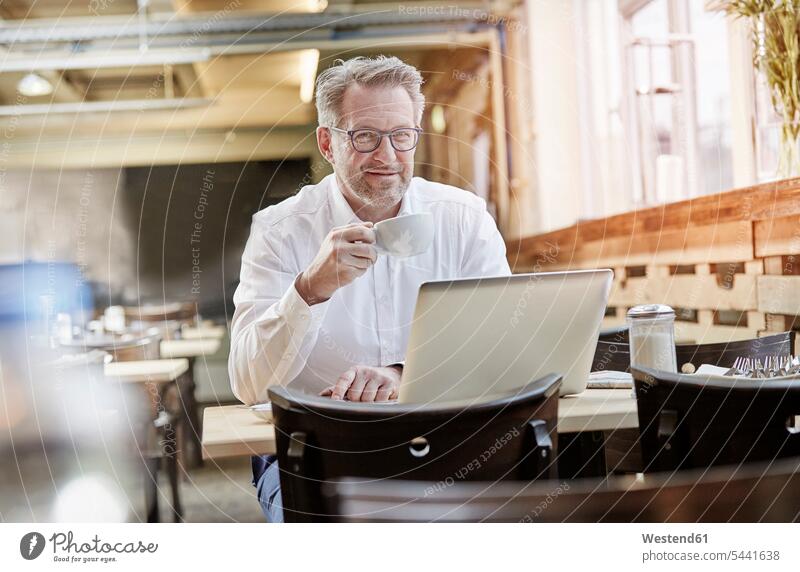 Porträt eines selbstbewussten reifen Geschäftsmannes im Café mit Laptop Notebook Laptops Notebooks lächeln Businessmann Businessmänner Geschäftsmänner arbeiten