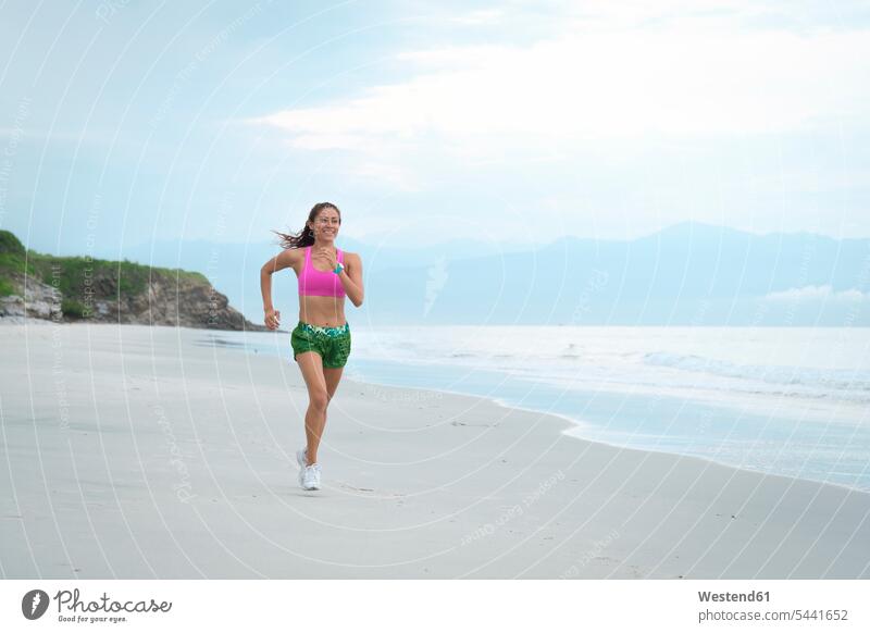 Frau rennt am Strand trainieren Joggerin Joggerinnen fit laufen rennen Beach Straende Strände Beaches sportlich weiblich Frauen Joggen Jogging Fitness