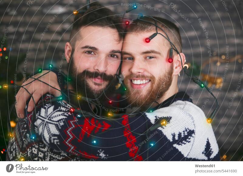 Porträt eines glücklichen schwulen Paares mit Lichterkette zur Weihnachtszeit Schwules Paar Schwuler Portrait Porträts Portraits Gleichgeschlechtliches Paar