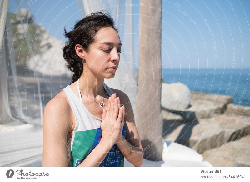 Frau macht eine Yoga-Übung an der Küste meditieren weiblich Frauen üben ausüben trainieren Kueste Kuesten Küsten Erwachsener erwachsen Mensch Menschen Leute