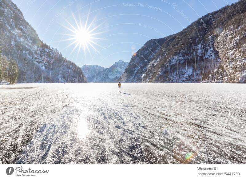 Deutschland, Berchtesgadener Land, Rückenansicht einer Frau mit Rucksack auf dem zugefrorenen Königssee stehend weiblich Frauen Erwachsener erwachsen Mensch
