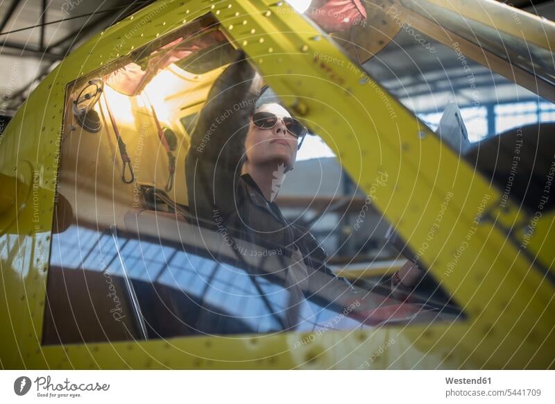 Weibliche Pilotin inspiziert Leichtflugzeug-Cockpit überprüfen testen checken sitzen sitzend sitzt Pilotinnen Flugzeug Flieger Flugzeuge inspizieren