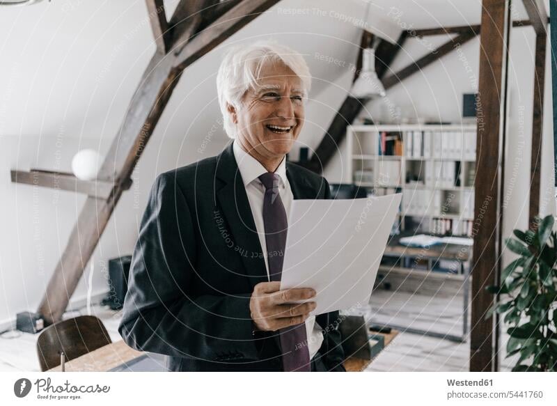 Porträt eines lächelnden Senior-Geschäftsmannes mit Dokument in seinem Büro Businessmann Businessmänner Geschäftsmänner Geschäftsleute Geschäftspersonen