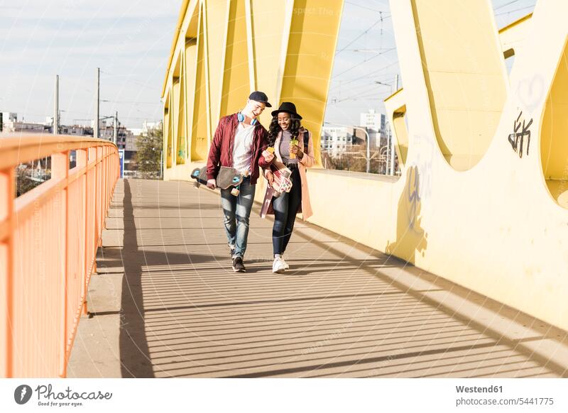 Junges Paar mit Skateboard auf der Brücke Spaß Spass Späße spassig Spässe spaßig Bruecken Brücken jung glücklich Glück glücklich sein glücklichsein fröhlich