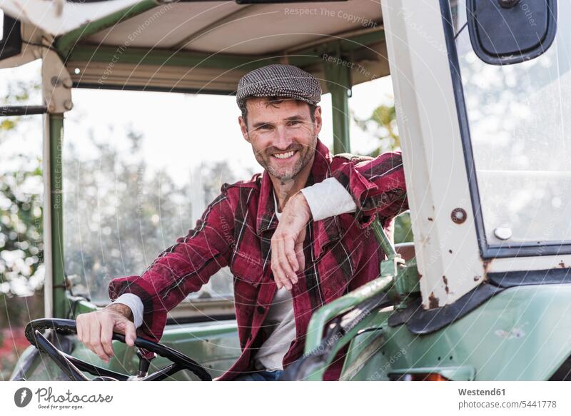 Porträt eines selbstbewussten Landwirts auf einem Traktor lächeln Schlepper Traktoren Trecker Portrait Porträts Portraits Bauer Landwirte Bauern Mann Männer