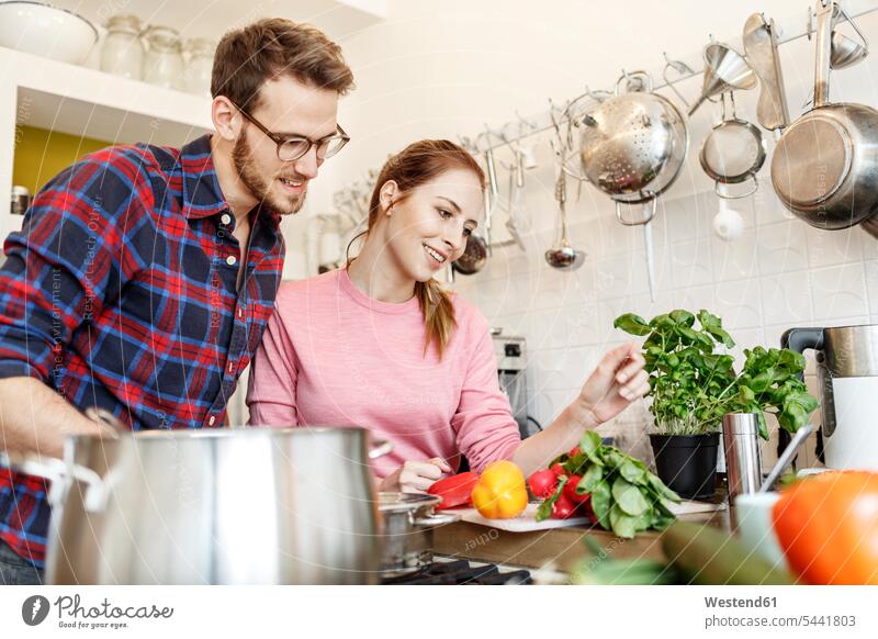 Glückliches junges Paar kocht gemeinsam in der Küche kochen glücklich glücklich sein glücklichsein Pärchen Paare Partnerschaft Gemeinsam Zusammen Miteinander