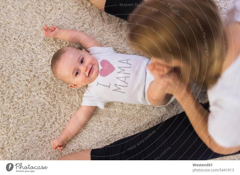 Mutter und kleiner Sohn spielen zu Hause Teppich Teppiche Boden Böden Boeden liegen liegend liegt Baby Babies Babys Säuglinge Kind Kinder Söhne Mami Mutti